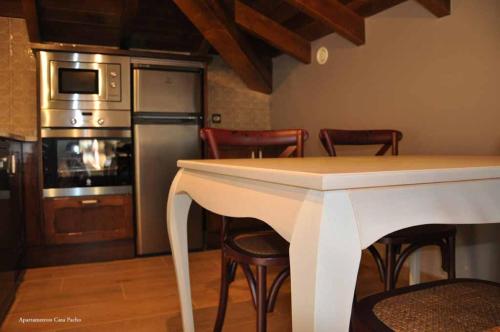 a kitchen with a table and chairs and a refrigerator at Casa Pacho Apartamentos Rurales in Luarca