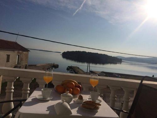 a table with food and wine glasses on a balcony at Apartments Esperanza in Pašman