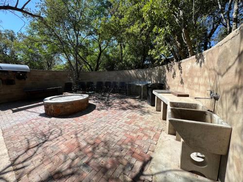 a brick courtyard with benches and a concrete wall at Nectar Game Lodge in Buffelspoort