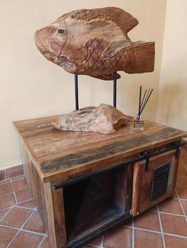 a wooden table with a fish sculpture on it at Maison Canopée in Messina