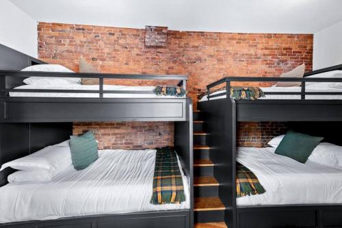 two bunk beds in a room with a brick wall at Downtown Kentucky Home Perfect for Groups in Louisville