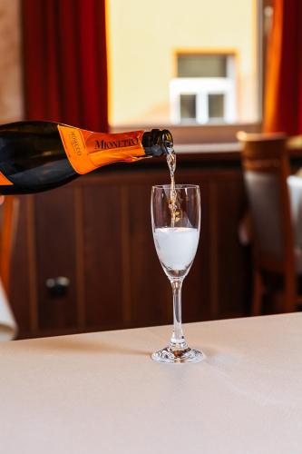 a bottle of wine being poured into a glass at JazzPenzion in Čadca