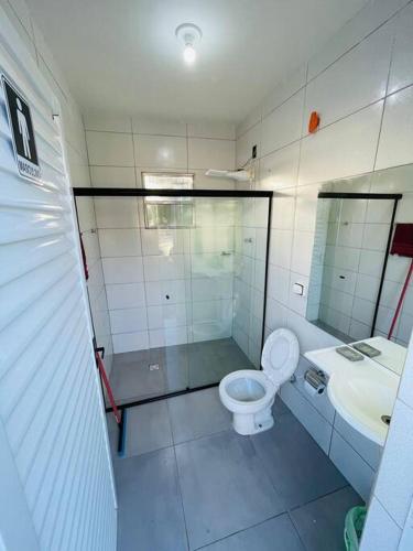 a bathroom with a shower and a toilet and a sink at Chácara Vovô Juca Pouso Alegre in Pouso Alegre