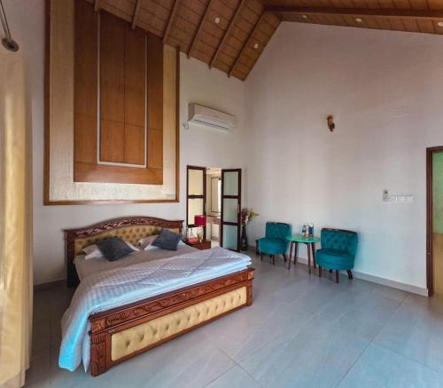a bedroom with a bed and a table and chairs at Poolside Villa in Dhaka