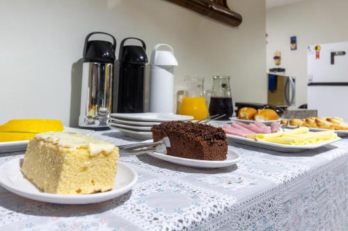 a table with two slices of cake on plates at Guest House 4 Anjinhos in Arraial d'Ajuda