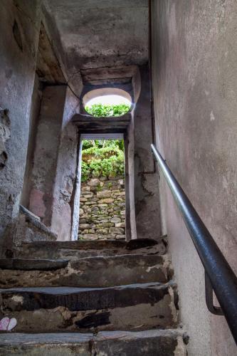 a stairway with a window and a stone wall at Casa del Borgo "Aria & Acqua" sul Lago Maggiore in Maccagno Inferiore