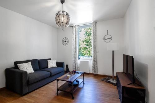 un salon avec un canapé bleu et une table dans l'établissement Sweet-patio, à Briey