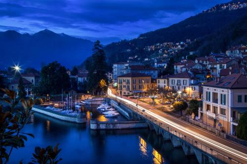 a city at night with boats in the water at Casa del Borgo "Terra & Fuoco" sul Lago Maggiore in Maccagno Inferiore