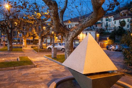a sculpture of a pyramid next to a tree at Casa del Borgo "Terra & Fuoco" sul Lago Maggiore in Maccagno Inferiore