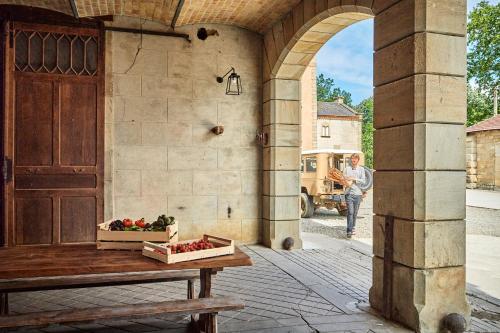 an archway with a table with a box of strawberries at Château de Sibra in Lagarde