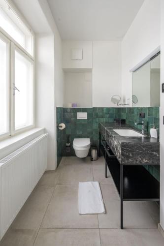 a bathroom with a sink and a toilet and a window at Designer Boutique Apartments Graz Trauttmansdorffgasse in Graz