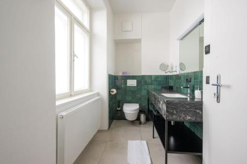 a bathroom with a sink and a toilet and a window at Designer Boutique Apartments Graz Trauttmansdorffgasse in Graz