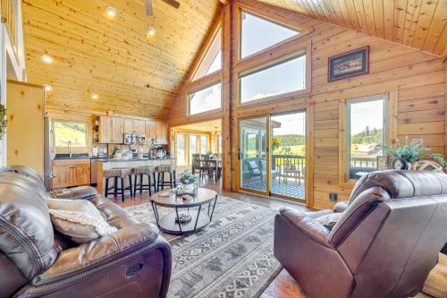 a living room with leather furniture and a kitchen at Lakefront Divide Cabin with Game Room! in Woodland Park