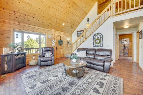 a living room with leather furniture and a staircase at Lakefront Divide Cabin with Game Room! in Woodland Park