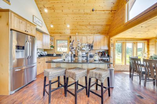 a kitchen with a center island with bar stools at Lakefront Divide Cabin with Game Room! in Woodland Park