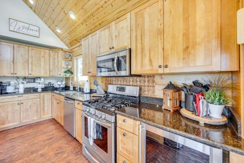 a kitchen with wooden cabinets and stainless steel appliances at Lakefront Divide Cabin with Game Room! in Woodland Park