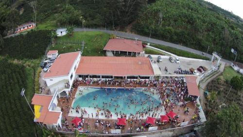 a large crowd of people standing around a swimming pool at Sky Club Eco Hotel in Belén de Umbría