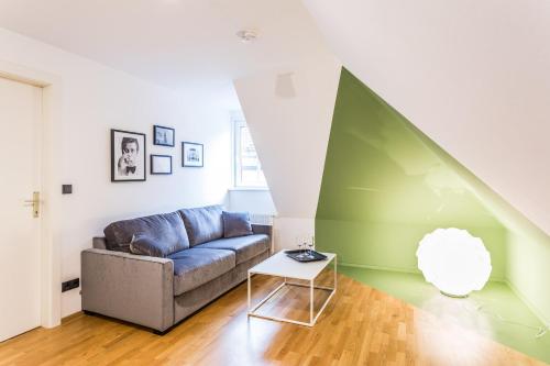 a living room with a couch and a table at Designer Boutique Apartments Graz Trauttmansdorffgasse in Graz