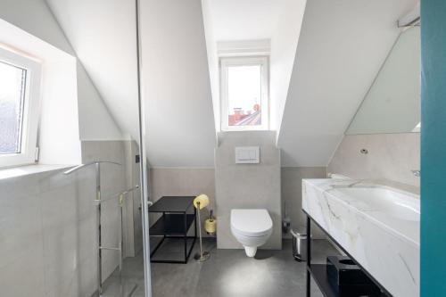 a white bathroom with a toilet and a sink at Designer Boutique Apartments Graz Trauttmansdorffgasse in Graz