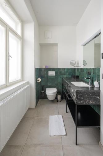 a bathroom with a sink and a toilet and a window at Designer Boutique Apartments Graz Trauttmansdorffgasse in Graz