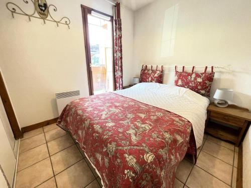 une chambre avec un lit avec une couverture rouge et une fenêtre dans l'établissement Résidence Les Oursons - Appartement au pied des pistes de l'Espace Diamant MAE-2324, à Notre-Dame-de-Bellecombe
