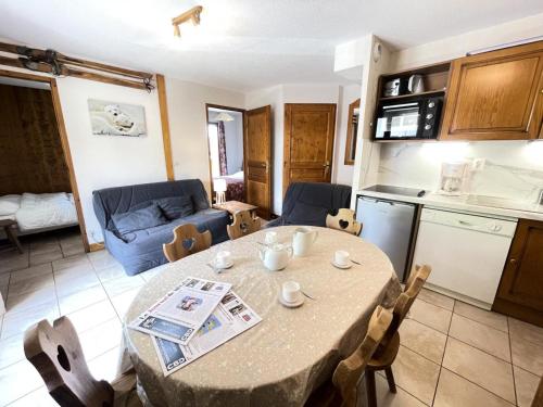 une cuisine et une salle à manger avec une table et des chaises dans l'établissement Résidence Les Oursons - Appartement au pied des pistes de l'Espace Diamant MAE-2324, à Notre-Dame-de-Bellecombe