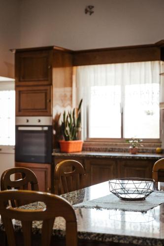 a kitchen with a table and chairs and a kitchen with a window at Quinta da Ponte by Gerês Casas in Terras de Bouro