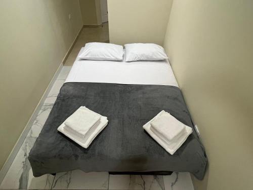 a bed with two pillows on top of it at Lucky center Apartment in Podgorica