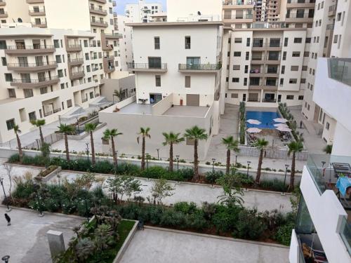 an aerial view of a courtyard with palm trees and buildings at Ocean Park Zenata City Eco in Casablanca