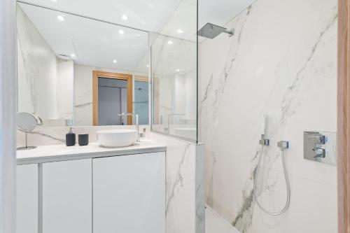 une salle de bain blanche avec un lavabo et une douche dans l'établissement Balcon sur la Méditerranée, à Nice