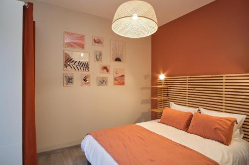 une chambre avec un grand lit avec une couverture orange dans l'établissement Superbe appartement proche cathédrale, à Reims