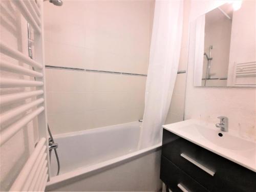 une salle de bain blanche avec une baignoire et un lavabo dans l'établissement Résidence Jetay - Appartement 4 personnes aux Ménuires avec vue sur la montagne MAE-5614, aux Menuires