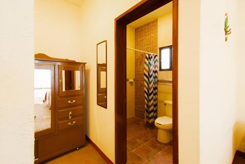 a bathroom with a toilet and a mirror and a door at Hotel Casa San Pablo in Oaxaca City