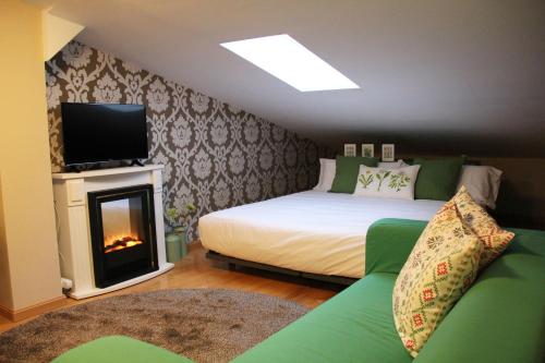 1 dormitorio con 1 cama y chimenea con TV en Apartamentos Vino y Camino, en Nájera