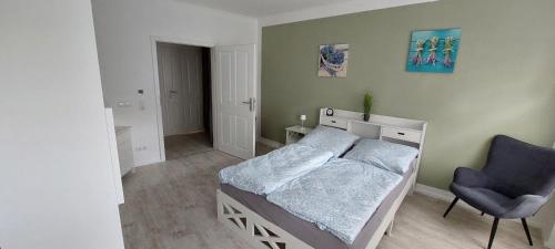 a small bedroom with a bed and a chair at Ferienwohnung Gertraude in Markranstädt