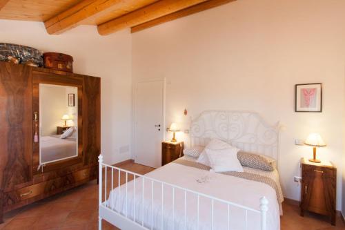 Ostra VetereにあるCasa Vacanze Angelicaのベッドルーム(白いベッド1台、鏡付)