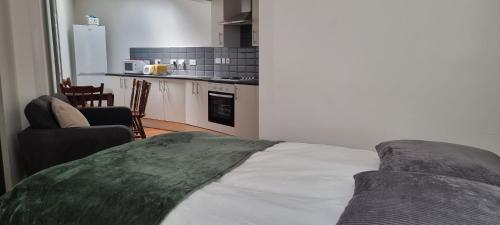 a living room with a bed and a kitchen at King's Cross Road Private Rooms in London