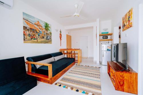 a living room with a couch and a tv at Jasiri Apartment, Beautiful ocean-view 2 bedroom home in Fumba Town in Dambani