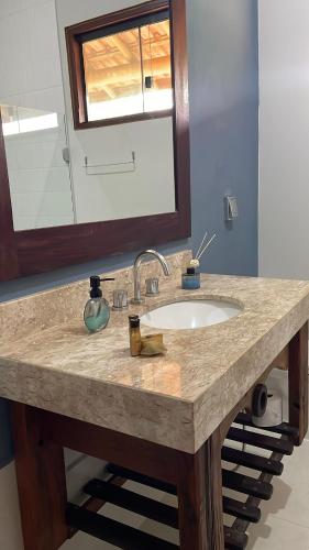 a bathroom counter with a sink and a mirror at Recanto da Natureza in Brotas