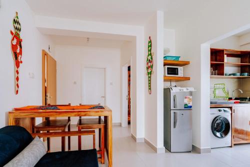 a living room with a table and a kitchen at Jasiri Apartment, Beautiful ocean-view 2 bedroom home in Fumba Town in Dambani