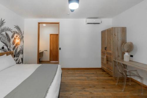 a bedroom with a bed and a desk at S Boutique Hotel in Bocas del Toro