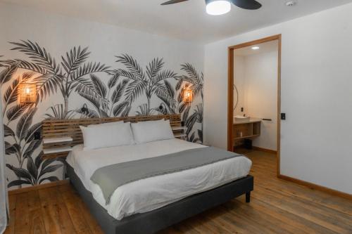 a bedroom with a large bed with a tropical wallpaper at S Boutique Hotel in Bocas del Toro