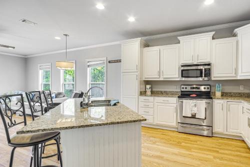 a kitchen with white cabinets and a counter top at Biloxi Condo with Community Pool about Half-Mi to Beach! in Biloxi