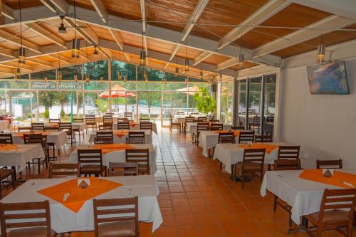 a restaurant with white tables and chairs and windows at Coral Clubes Santa María in Tlalmanalco de Velázquez