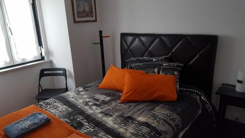 1 cama con almohada naranja y cabecero negro en Encanto da Paz en Lisboa