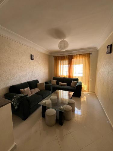 a living room with a couch and a table at Marhaban U2 in Martil