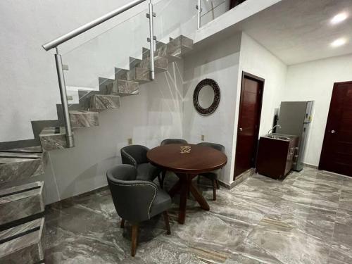 a room with a table and chairs and a staircase at Departamento completamente nuevo y amueblado in Tonalá