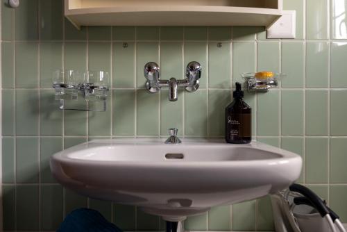 a sink in a bathroom with a bottle and glasses at Blattenheimat6 - im traditionellen Appenzeller Haus in Appenzell