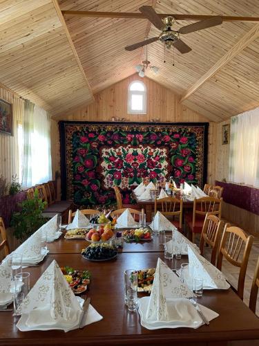 a dining room with a table with plates of food at La Nea Ion in Ţaul