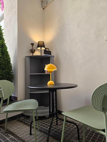a table with a yellow lamp on it next to two chairs at Casa LoRè in Torre Annunziata